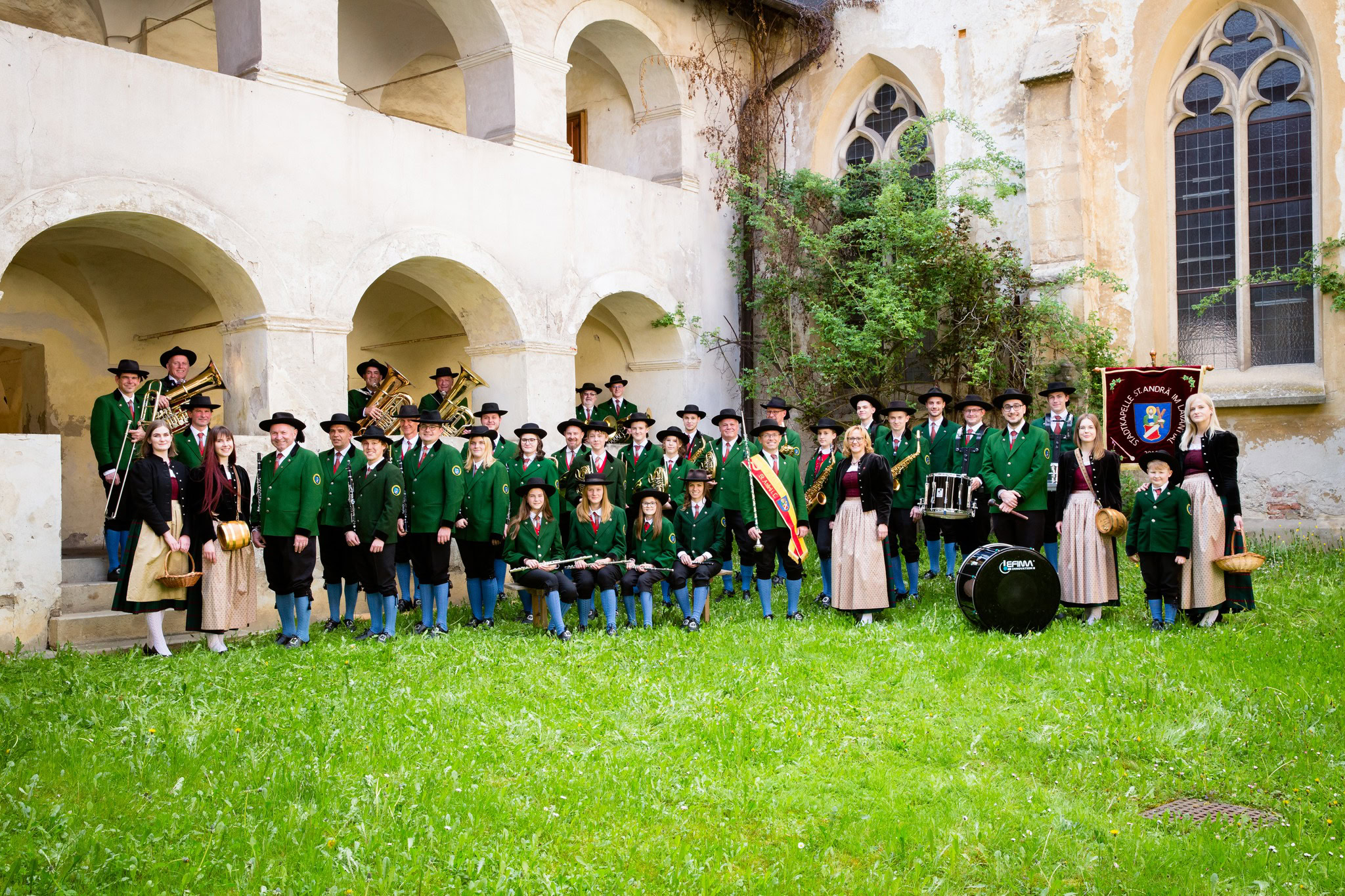 Gruppenfoto Stadtkapelle St. Andrä im Lavanttal in traditioneller Tracht vor historischen Gebäuden